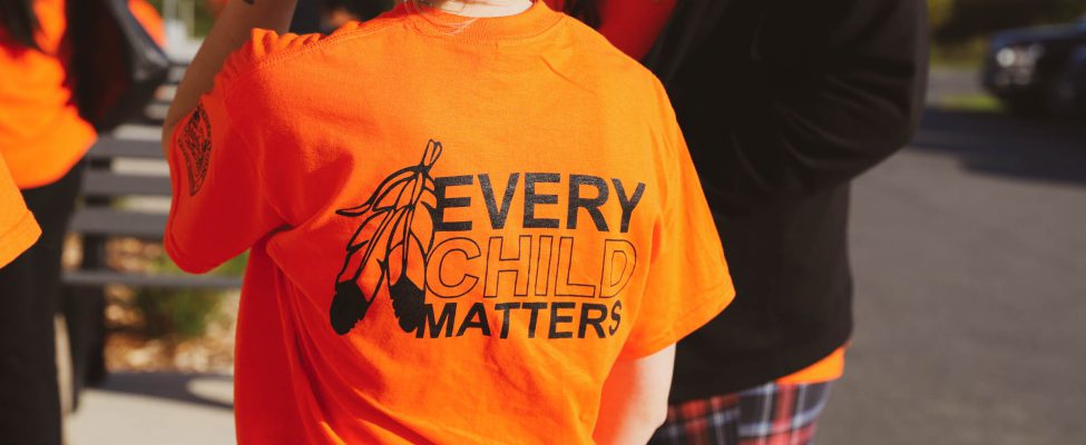 A person wearing an "Every Child Matters" shirt.